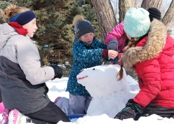 Girls build a snow dog