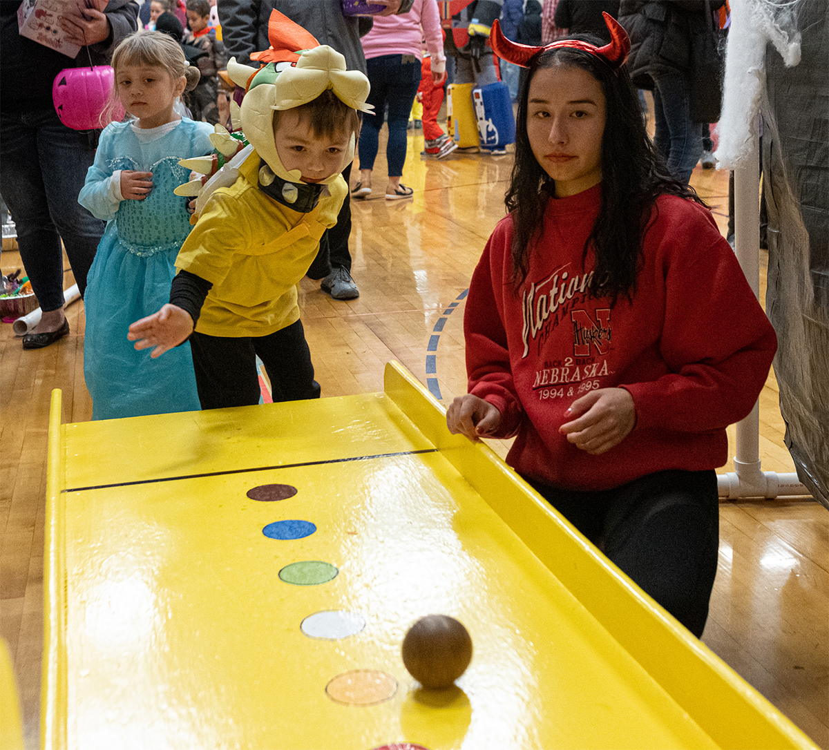 Kids in costumes playing skeeter's ball