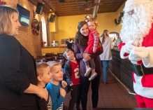 Sarah Dein with twins Jacob and Jackson and Amelia Jacobitz holding daughter Vera and with son Graham meet Santa.