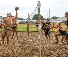 Balls in Your Face take on the the Ball Busters in mud volleyball competition Sunday.